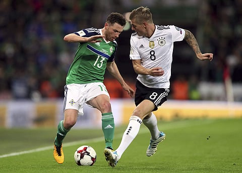 Northern Ireland's Corry Evans, left, and Germany's Toni Kroos battle for the ball during their 2018 World Cup Group C qualifying soccer match at Windsor Park, Belfast, Thursday, Oct. 5, 2017. | AP