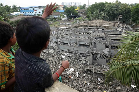 A boy explaining to his friend how was demolished at Moulivakkam in Chennai on Thursday.(Sunish P Surendran | EPS)