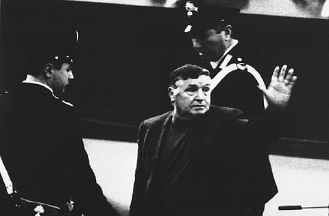In this March 4, 1993 file photo, Mafia boss Salvatore Riina waves to family and supporters as he is taken away by police following a court appearance in Palermo, southern Italy. (AP File Photo)