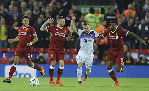 Liverpool's Georginio Wijnaldum, right, Alberto Moreno, 2nd left, and Alex Oxlade-Chamberlain, left, challenge Maribor's Dino Hotic, 2nd right, during the Champions League Group E soccer match between Liverpool and Maribor at Anfield, Liverpool, England,