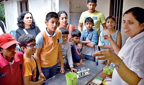 Children learn a science experiment from a facilitator at the Open Day event at Sir CV Raman’s house in Panchavati on Sunday | JITHENDRA M