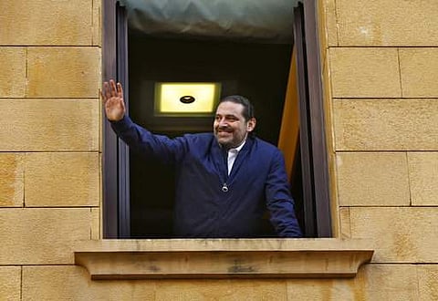 Lebanese Prime Minister Saad Hariri waves to his supporters from a window of his residence, in Beirut.|AP
