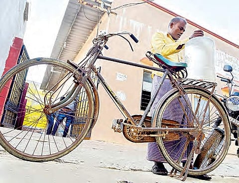A villager fetches a can of water from a water plant travelling on his bicycle in Sangareddy on Friday | r satish babu