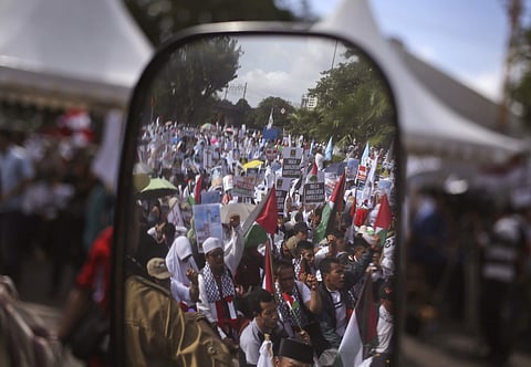 Protesters are reflected on the mirror of a truck as they shout slogans during a rally against President Donald Trump's decision to recognize Jerusalem as Israel's capital outside the U.S. Embassy in Jakarta
