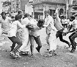 ready to strike a blow on then Congress leader Mamata Banerjee as other Congress leaders try to protect her in Kolkata on August 16, 1990. | Express