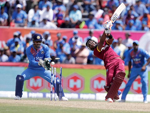 West Indies' Dwayne Bravo right is bowled by India's Amit Mishra as India's MS Dhoni left looks on during the second Twenty20 international cricket match Sunday Aug. 28 2016 in Lauderhill Fla. | AP