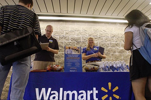 In this Sept. 1, 2011, photo, Wal-Mart employees Jon Christians and Lori Harris take job applications and answers questions during a job fair at the University of Illinois Springfield campus in Springfield, Ill. | AP