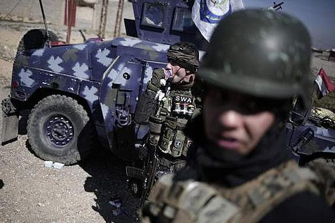 A member of the federal police takes a break from fighting Islamic State militants, in Hamam al-Alil, Iraq