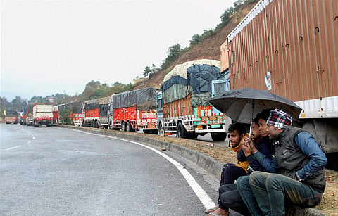 Goods trucks, wait for the reopening of the Jammu-Srinagar highway which was closed following heavy rains and snowfall.