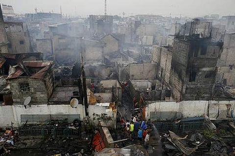 Fire victims sift through the debris following an overnight fire that swept an informal settlers' community near the port Wednesday, Feb. 8, 2017 in Manila, Philippines. Fire officials said no casualties were reported but more than a thousand homes were d