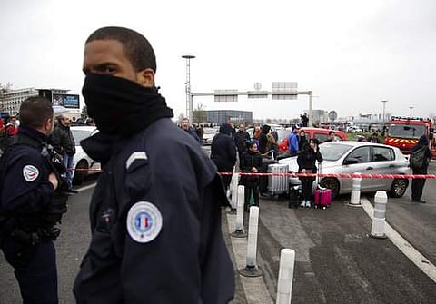 A French police officer guards travelers waiting outside the Orly airport , south of Paris, March, 18, 2017. AP