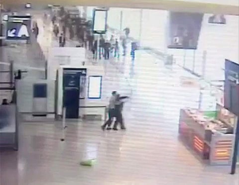 Suspected Islamic extremist Ziyed Ben Belgacem, center left, holds a soldier after grabbing her from behind at Paris’ Orly airport. AP