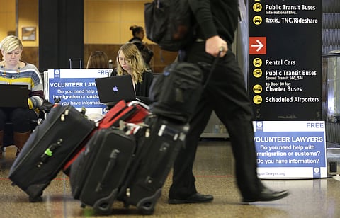 A volunteer law student from the University of Washington, works at a station near where passengers arrive on international flights at Seattle-Tacoma International Airport (File Photo | AP)