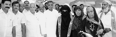 Former chief minister B S Yeddyurappa, BJP candidate V Srinivasa Prasad and others with Muslims who joined BJP at a function in Kavalande in Nanjangud on Sunday | express