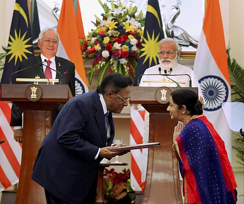 Prime Minister Narendra Modi with his Malaysian counterpart Najib Razak looks as External Affairs Minister Sushma Swaraj exchange the documents at Hyderabad House in New Delhi on Saturday. (Photo | PTI)