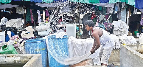 A dhobi washing hospital linen at the Chetpet dhobi khana, Chennai, on Wednesday. Linen bearing tags of several major hospitals in the city were seen at the location. | Express File Photo