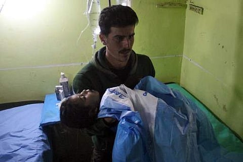 An unconscious Syrian child is carried at a hospital in Khan Sheikhun, a rebel-held town in the northwestern Syrian Idlib province, following a suspected toxic gas attack on April 4, 2017. (AFP)