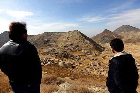 Abdul Qadir Timor, director of archaeology at the Ministry of Information and Culture, left, looks at the view of Mes Aynak valley, some 40 kilometers (25 miles) southwest of Kabul. (File Photo | AP)