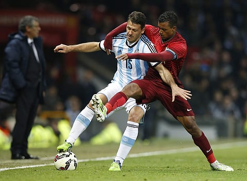 In this Nov. 18, 2014 file photo Martin Demichelis of Argentina, left, is challenged by Nani of Portugal during their International Friendly soccer match at Old Trafford Stadium, Manchester, England. | AP