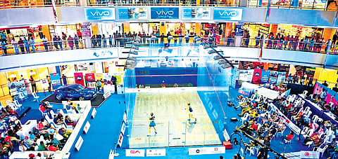 Shoppers stop to catch a glimpse of the Asian Squash Championships at Express Avenue mall in Chennai. A specialised glass court brought from Mumbai was used for the event