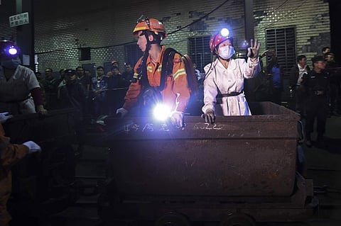 A medical staff member gestures next to a rescuer as they prepare to enter the Jilinqiao coal mine in Huangfengqiao township, Youxian county, central China's Hunan province, Monday, May 8, 2017. (Photo|AP)