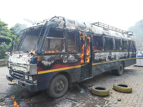 A police vehicle set on fire on the Thane-Badlapur highway where farmers are protesting against their land being acquired by the Navy. (EPS)