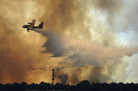 A fire fighting aircraft drops water over a fire outside the village of Pedrogao Grande central Portugal. | AP