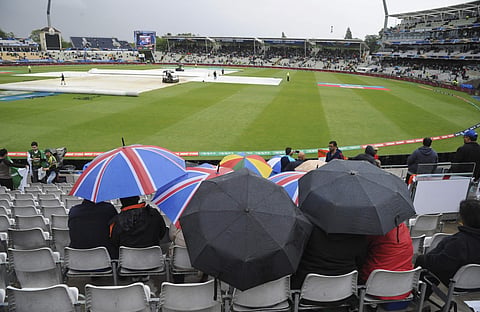 Spectators wait for play to resume after it was disrupted by rain during the ICC Champions Trophy match between India and Pakistan at Edgbaston in Birmingham. | AP