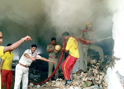 Firemen dousing flames in the biscuit factory at Patia in Bhubaneswar on Monday | Express