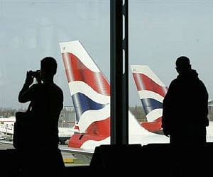 A passenger photographs British Airways aircraft with his mobile telephone at Heathrow Airport near London. (File photo/Reuters)