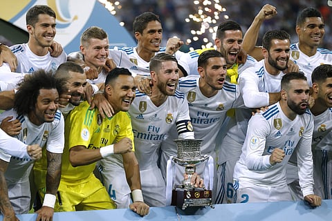 Real Madrid's players celebrate with their trophy after winning the Spanish Super Cup against Barcelona at the Santiago Bernabeu Stadium. | AP