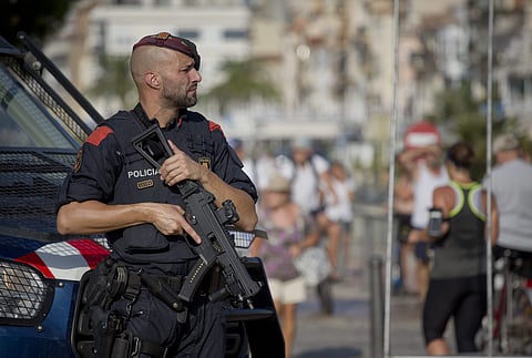 An armed policeman stands on the spot where terrorist were shot by police in Cambrils, Spain. (Photo | AP)
