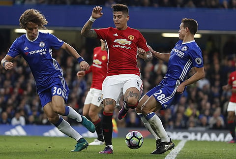 Manchester United’s Marcos Rojo, center, Chelsea’s David Luiz, left, and Chelsea’s Cesar Azpilicueta challenge for the ball during the English Premier League soccer match. | AP