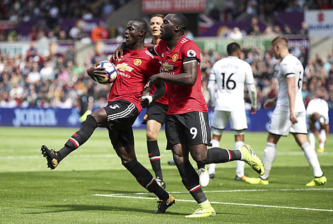 Manchester United's Eric Bailly, left, celebrates with teammate Romelu Lukaku after scoring his side's first goal during their English Premier League soccer match at the Liberty Stadium. | AP