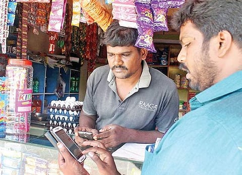 A shopkeeper getting insight into digital banking experience. (Express Photo Service | S Dinesh)