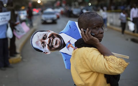 A supporter of main opposition leader Raila Odinga holds a placard of his face as she attends a small demonstration outside the Supreme Court in downtown Nairobi, Kenya Friday, Aug. 18, 2017. | AP
