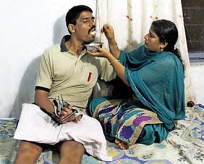 Former NSG commando Sriramulu, who was crippled after receiving sharpnel injuries in Pathankot Air Force base terror attack, being attended to by his wife at his residence in Hyderabad | SATHYA KEERTHI