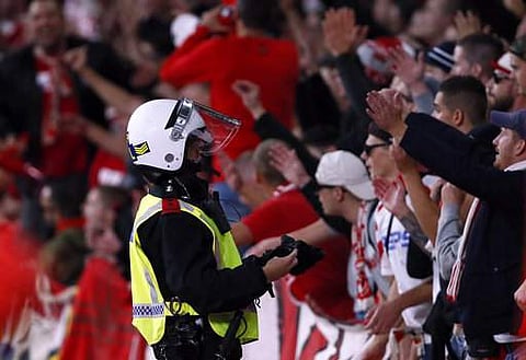A police officer watches Cologne supporters during the Europa League group H soccer match between Arsenal and FC Cologne at the Emirates stadium in London. | AP
