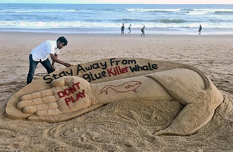 Sand artist Sudarsan Patnaik creates a sculpture to create awareness on Blue Whale game on Puri beach on Monday. | Express Photo Service