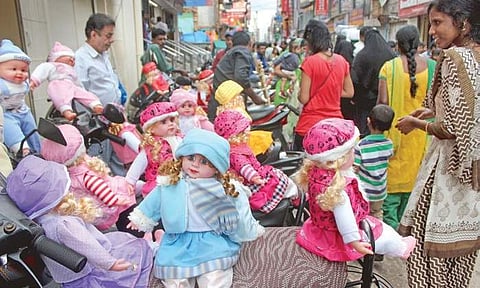 A doll seller sets up shop on a pavement in Chikpet on Monday |S Manjunath