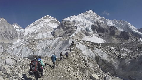 International trekkers pass through a glacier at the Mount Everest base camp, Nepal.