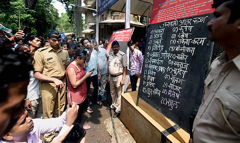Relatives check for the names of injured victims of the stampede at a hospital in Mumbai on Friday. | PTI