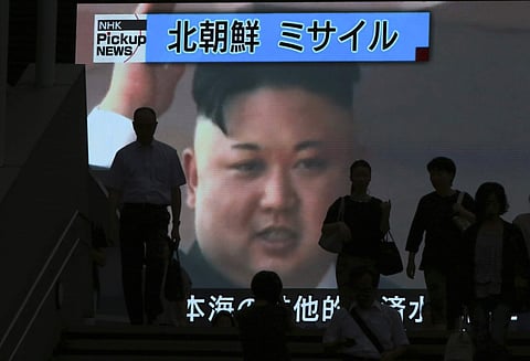 People walk past a TV news showing an image of North Korean leader Kim Jong-un. (File photo | AP)