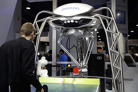 An attendee plays table tennis with Omron's Forpheus at CES International, Wednesday, Jan. 10, 2018, in Las Vegas. (AP Photo/Jae C. Hong)