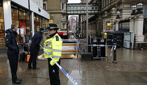 Commuters look past a police cordon as they get to their place of work in the area near a major gas leak near Charing Cross railway station in central London | AP