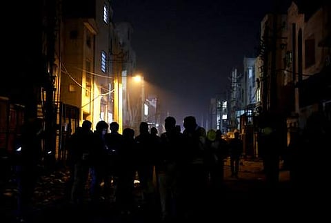 This picture shows policemen and security personnel stand outside a burnt firecracker factory on the outskirts of New Delhi, early Sunday. (Photo | AP)