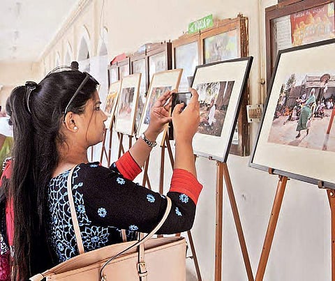 A girl takes a picture at the photo exhibition on the second day of Lit Fest in Hyderabad 2024 on Saturday
