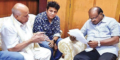 Actor Shivarajkumar and Karnataka Film Chamber of Commerce president S A Chinne Gowda meeting CM H D Kumaraswamy in Bengaluru on Thursday