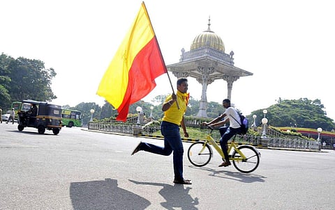 A Kannada activist seen running with the Karnataka flag on the occasion of Karnataka Rajyotsava in Mysuru on Wednesday. (File Photo | EPS/Udayashankar S)