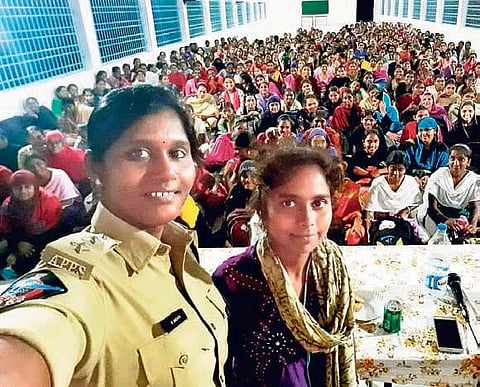Tenali DSP M Snehita takes a selfie with a girl student during an awareness programme at a college in Guntur district on Friday I Express